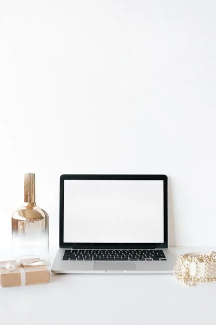 Gros plan d’un smartphone affichant une image floue, posé sur un bureau à côté d’un ordinateur portable.